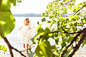 Mädchen im Sommerkleid steht im Starnberger See, Berg, Oberbayern, Bayern, Deutschland