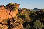 Red stone cliffs with trees and Elephant Rock in the distance, Hidden Valley National Park, near Kununurra, Western Australia, Australia