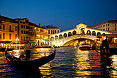 Silhouette einer Gondel am Canal Grande vor der beleuchteten Rialtobrücke in der Dämmerung, Venedig, Venetien, Italien, Europa