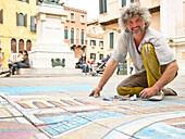 Straßenkünstler Luciano Gazzaniga malt ein Gemalde mit Kreide auf einem Platz an der Strada Nova, Venedig, Venetien, Italien, Europa