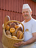 Baker Erwin Oehl with a basket of baked goods at his backery, Frankenau, Hesse, Germany, Europe