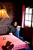 Frau mit einer Tasse Tee ließt ein Buch, Steiermark, Österreich