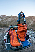 Two men with sleeping bags on off-road vehicle platform, Las Lenas, Mendoza, Cuyo, Argentinia