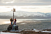 Skiers at summit in midnight sun, Tromsoe, Troms, Norway
