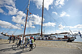 Cyclists beside landing pier in harbor, Stralsund, Mecklenburg-Western Pomerania, Germany