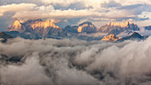 The sunset's light is on fire some dolomite's peak, surrounded by a cloud's sea, Dolomites, Italy