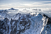 Border ridge between Bregaglia valley , Switzerland and Masino valley , Italy from helicopter. On the right the Bondasca summit with its glacier and crevasses. In the background the mount Disgrazia, Alps, Switzerland
