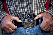 'A rancher wears a belt buckle that reads ''Bullshit''.'