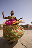A young girl performing a tradional dance in the town of Jodphur, Rajasthan in India.