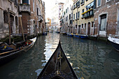 A gondola makes its way down a Venice canal, piloted by Alexandra Hai, the first woman gondolier in Venice.