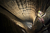 Cave explorer Duncan Collis ascends a rope in Miao Keng, the largest underground shaft in the world in Wulong County, China.