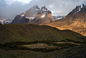 The Cuernos del Paine, or Paine Horns, peak from the mist over Lago Nordenskjold umlaut on second o, at Torres del Paine National Park in Southern Chile.