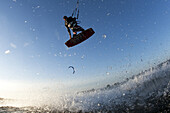 Kelton Rappleyea flying high and throwing a grab while kiteboarding off of Sauvie Island near Portland, Oregon.