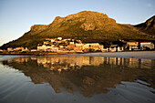 Sunrise forms a reflection of the small coastal town of Muizenberg on its beach in Cape Town, South Africa on April 18, 2008.