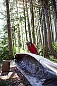TOFINO, BRITISH COLUMBIA, CANADA. A man native to the West Coast of Vancouver Island carves a canoe as his tribes have for centuries.