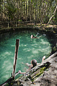 Two girls swimming in a cenote near Progreso in Yucatan, Mexico.