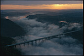 Aerial view of the bridge crossing New River Gorge in West Virginia, engulfed by clouds and fog.