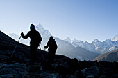 Hikers silhouetted against a sunrise mountain backdrop above Dhugla, 16,000ft.-trek to mt. everest base camp.
