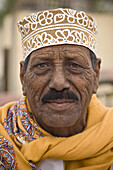 A smiling Omani man with traditional clothing in Salalah, Oman.
