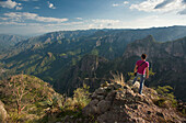 A man standing on the ridge of a cliff at the Copper Canyon in the region of Cerocahui,  Chihuahua  Mexico.