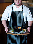 A chef displays a large sea urchin at the Sea Rocket Bistro restaurant in San Diego,  Ca. The urchin was caught only hours earlier by a San Diego diver,  who personally delivers his catch to various seafood restaurants in the area.