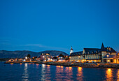 PUERTO NATALES, PATAGONIA, CHILE. A waterfront town is lit up at night.