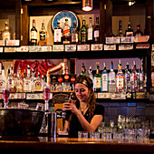 VANCOUVER, BRITISH COLUMBIA, CANADA. A woman pours a beer at a bar.