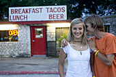 A young couple share a kiss in front of Rosie's Tamale House, an institution in Bee Cave, Texas for generations.