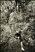MOUNT TARANAKI, NEW ZEALAND-JANUARY: Amber Meyer, a visiting American tourist, trail runs through the thick forest surrounding Mount Taranaki, North Island, New Zealand. Photo by Kyle George/ Aurora