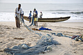 Brenu - Akyinim, GHANA : Fishermen sorting out their nets.  The fishing village of Brenu-Akyinim is located 10 km west of Elmina and features a long  sandy beach lined with palm trees often packed with fishermen and their boats.   Photo by: Christopher He