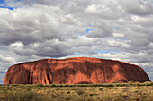 ULURU, AUSTRALIA - JULY 21: Passing clouds cast shadows on the large monolith rock Uluru at  Uluru - Kata Tjuta National Park in the Northern Territory of Australia, July 21, 2006. The rock, also known as Ayers Rock, is owned by the aboriginal people in t