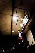 Wide shot of a basketball player slamming a ball.