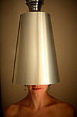 A woman stands under a stainless steel lamp shade in a hotel room in Prague, Czech Republic. hwilmeth_03.jpg