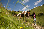 ALPS, SAVOIE, FRANCE-SEPTEMBER 12, 2007: GIrls walking their horses in the French Alps in Savoie, France on September 12, 2007.