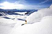 Skier skiing down the mountain in fresh powder snow, Kaltenbach, Zillertal, Austria