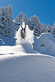 Skifahrer macht Backflip im Wald, Kaltenbach, Zillertal, Österreich