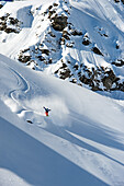 Snowboarder jumping and spreading his arms like a bird, Hochfuegen, Zillertal, Austria