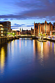 Beleuchteter Magdeburger Hafen mit Speicherstadt im Hintergrund, Hafencity, Hamburg, Deutschland