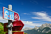 Cycle route signpost with mountains in background, Lower Engadin, Canton of Graubuenden, Switzerland