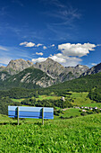 Blue bench with view to castle of Tarasp and Sesvenna range, Lower Engadin, Canton of Graubuenden, Switzerland
