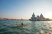 Paddler in front of historic church on Canal Grande, Venice, Italy