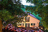 Menschen sitzen draußen beim Weinfest an der Peterstirn am Weingut Dahms in der Dämmerung, Schweinfurt, Franken, Bayern, Deutschland