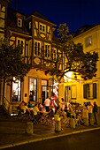 People outside bar 30 Leut' at night, Aschaffenburg, Franconia, Bavaria, Germany