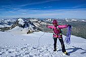 Woman standing on glacier of Gran Paradiso and gathering rope, Gran Paradiso, Gran Paradiso Nationalpark, Graian Alps range, valley of Aosta, Aosta, Italy