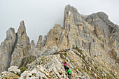 Personen gehen über Felsgrat zum Torre di Pisa, Latemar, Dolomiten, UNESCO Welterbe Dolomiten, Trentino, Italien