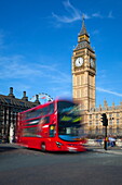 Motion blurred red London bus below Big Ben, Parliament Square, Westminster, London, England, United Kingdom, Europe