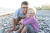 Vater und Sohn (4 Jahre) am Strand lächeln in die Kamera, Klintholm, Insel Mön, Dänemark