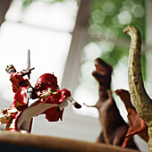 Toy knight fighting against toy dinosaurs