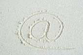 At symbol traced in sand, close-up