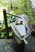 Stone water fountain with bamboo spigot and ladle